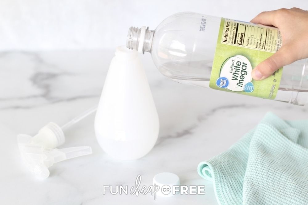 pouring vinegar into a spray bottle, from Fun Cheap or Free