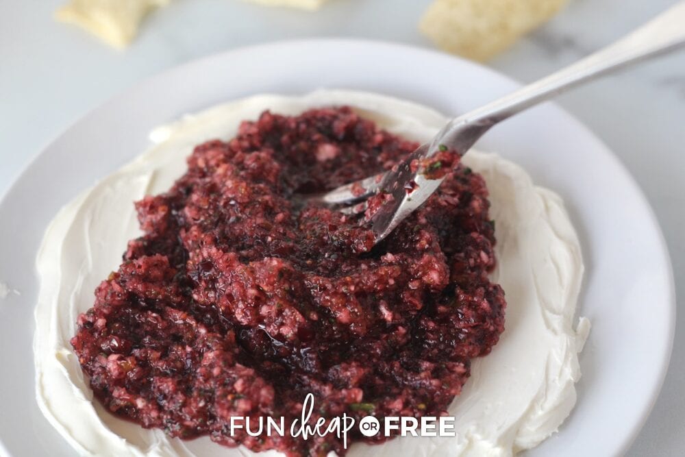 Spreading cranberry salsa over the softened cream cheese, from Fun Cheap or Free