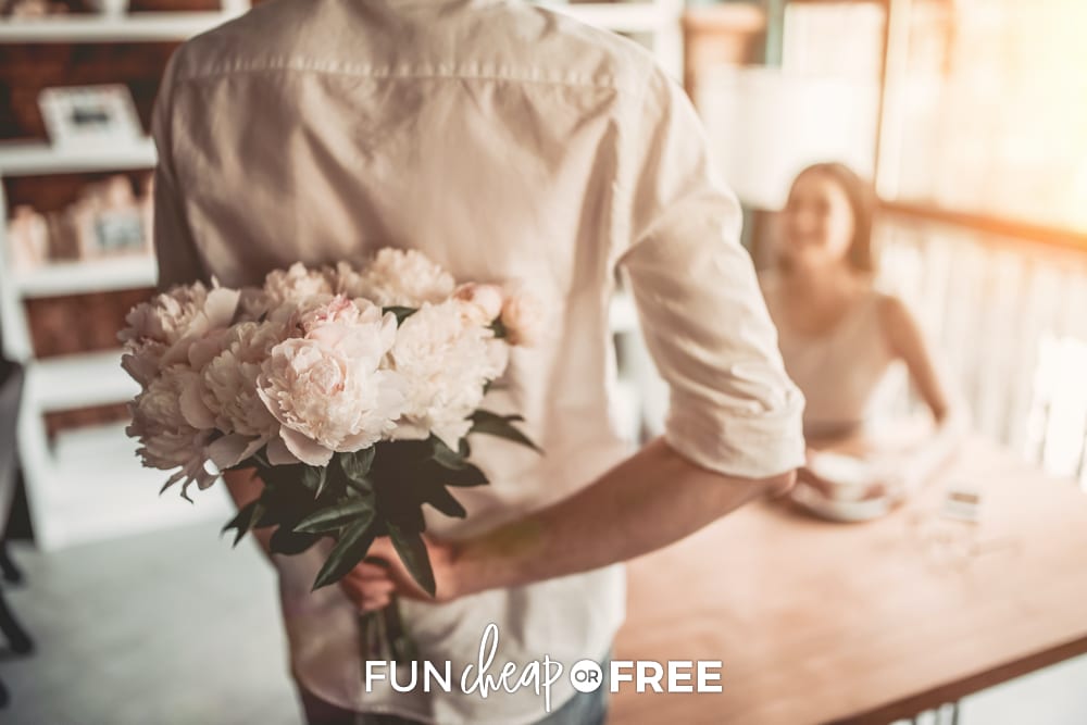 Man holding flowers behind his back, from Fun Cheap or Free