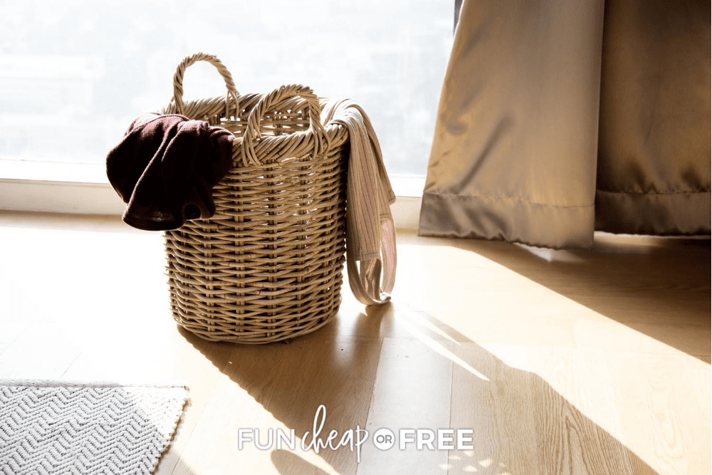 A catch-all basket on the floor with clothes inside from Fun Cheap or Free