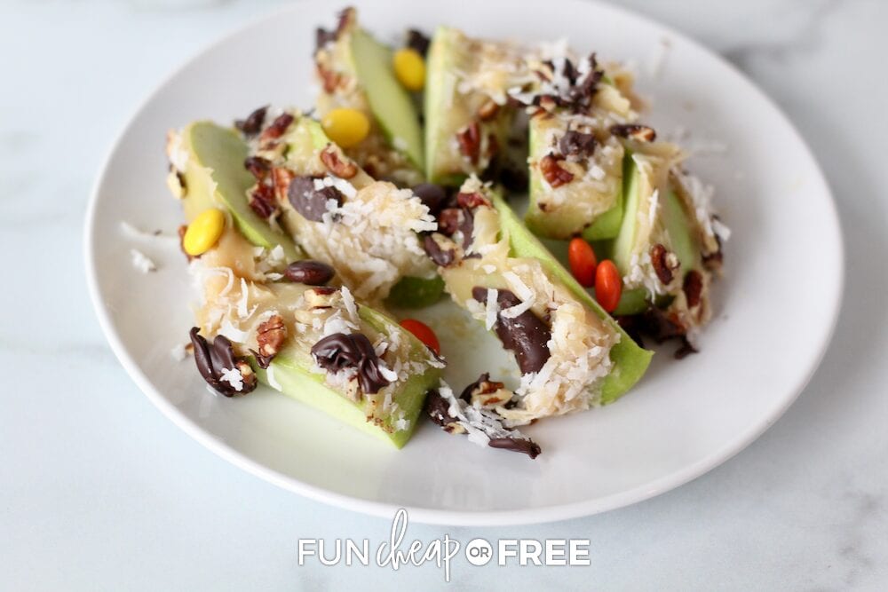 Sliced apple topped with caramel, chocolate chips, and shredded coconut, from Fun Cheap or Free