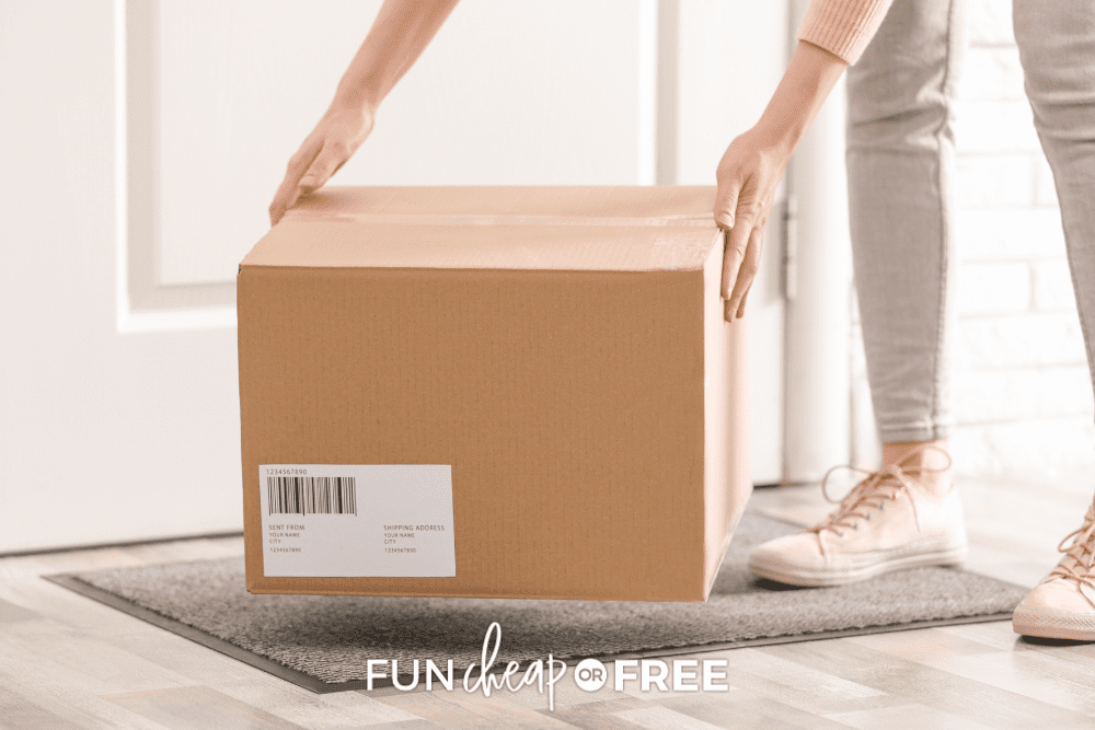 Woman in pink top and grey jeans picking up package from front door step, from Fun Cheap or Free