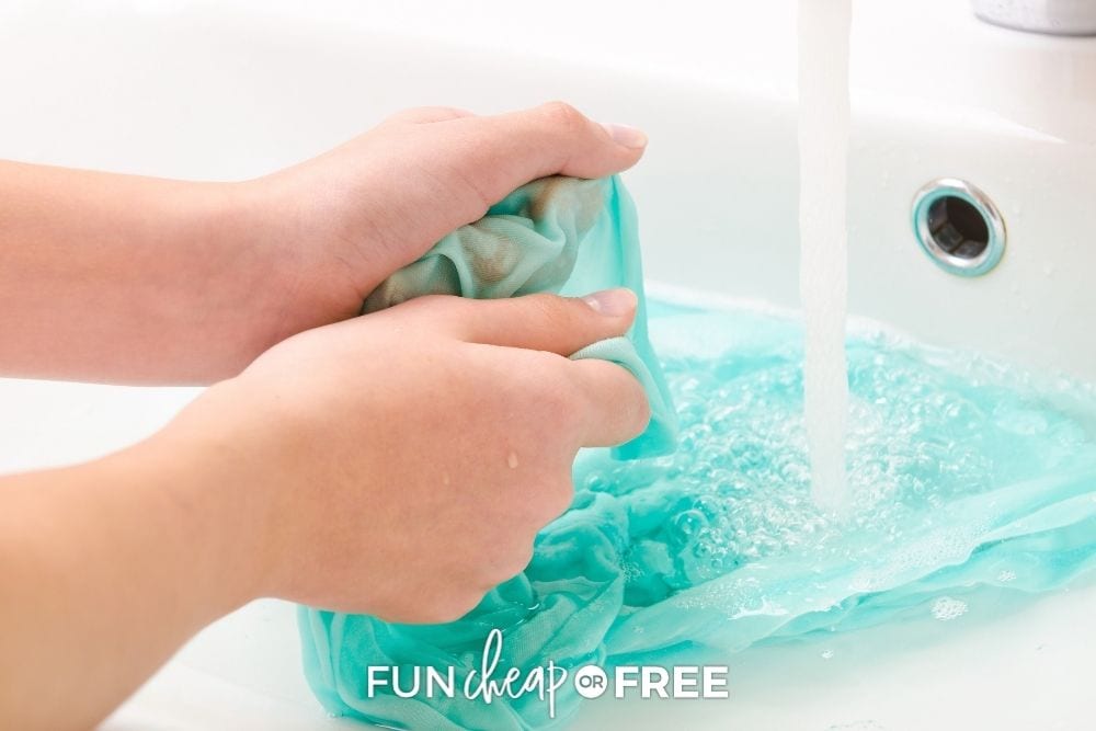 Hands rinsing stain from clothing in the sink from Fun Cheap or Free. 