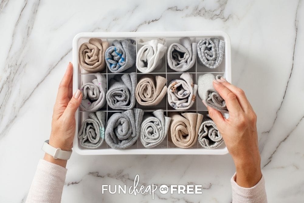 Hands organizing scarves in a bin from Fun Cheap or Free. 