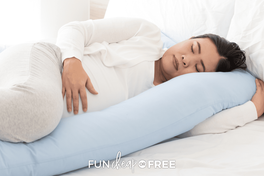 Woman sleeping with pregnancy pillow from Fun Cheap or Free. 