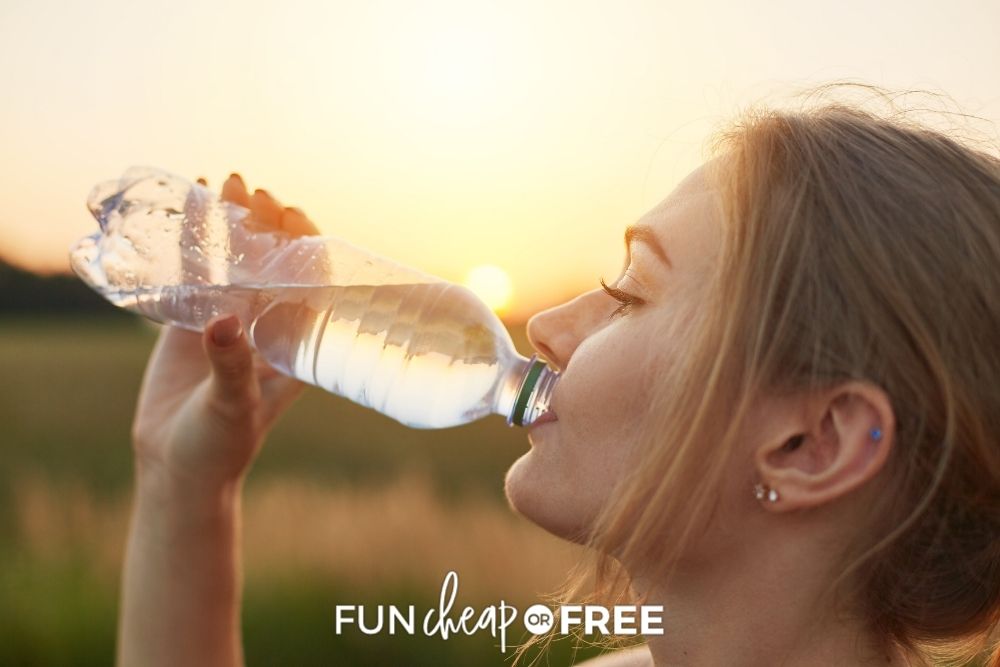 Woman drinking water from a bottle from Fun Cheap or Free. 
