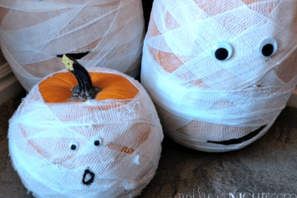 Orange pumpkins wrapped in gauze and decorated with silly eyes to look like mummies. 