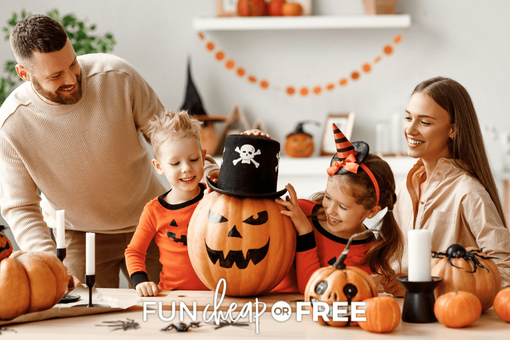 Parents and two young children decorating Halloween pumpkins together without carving them. - Fun Cheap Or Free
